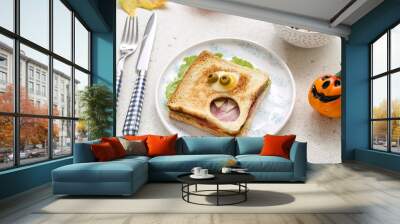 Plate with funny Halloween sandwich, cutlery and decor on light background Wall mural