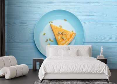 Plate with slice of tasty pumpkin pie on wooden background Wall mural