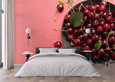 Plate with sweet cherries on red background Wall mural