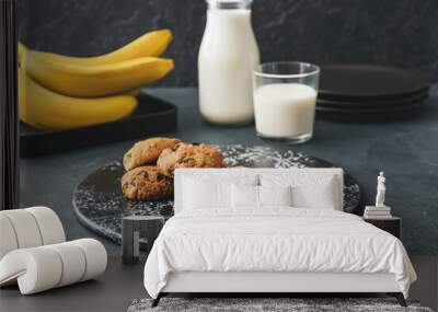 Plate with tasty banana cookies on dark background Wall mural