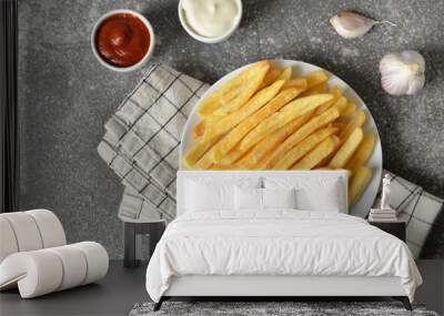 Plate with tasty french fries and sauces on grey background Wall mural