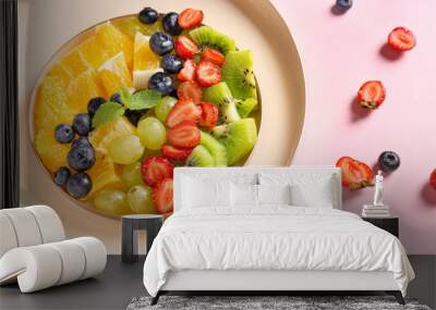 Plate with tasty fruit salad on color background Wall mural