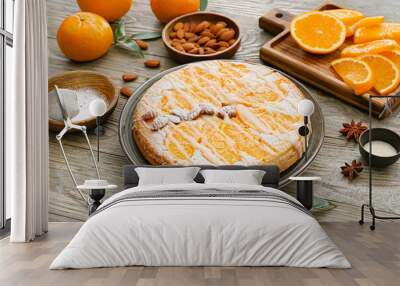 Plate with tasty orange pie and ingredients on wooden background Wall mural