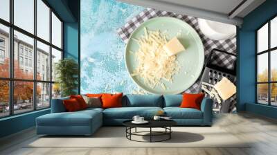 Plate with tasty Parmesan cheese and grater on table Wall mural