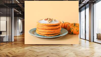 Plate with tasty pumpkin pancakes on color background Wall mural