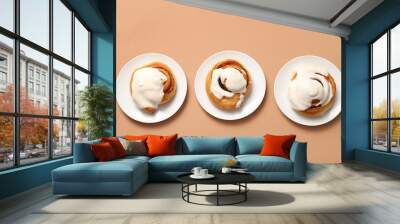 Plates of sweet cinnamon rolls with glaze on brown background Wall mural