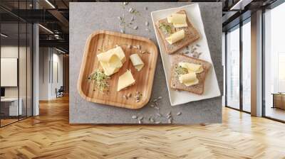 Plates with tasty butter and bread on grey table Wall mural