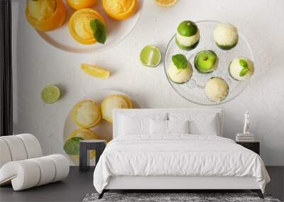 Plates with tasty ice creams in citrus fruit peels on light background Wall mural