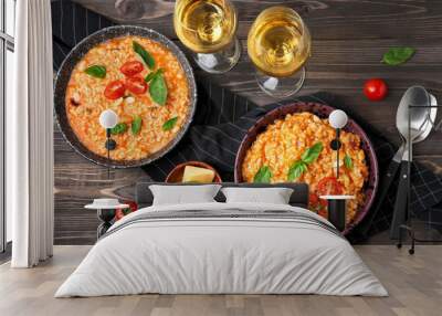 Plates with tasty risotto and glasses of wine on wooden table Wall mural