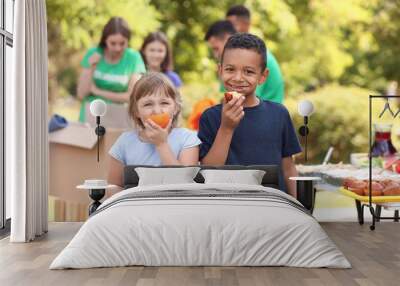 Poor little children with received food from volunteers outdoors Wall mural