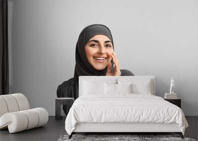 Portrait of beautiful Muslim woman in hijab on grey background Wall mural