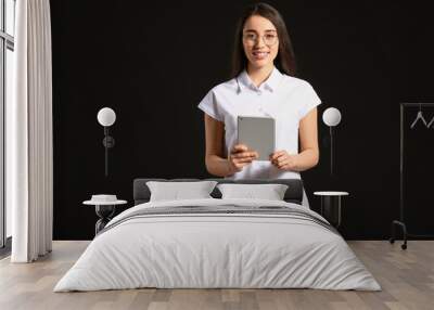 Portrait of beautiful young businesswoman with tablet computer on dark background Wall mural