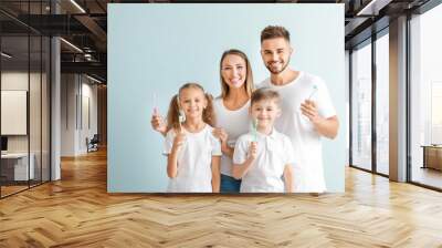 Portrait of family with toothbrushes on light background Wall mural