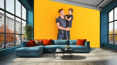 Portrait of father and son on color background Wall mural