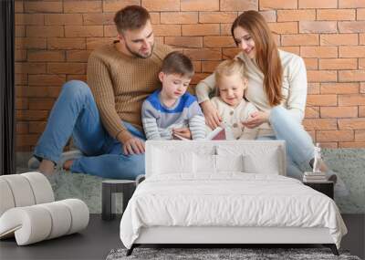 Portrait of happy family reading book near brick wall Wall mural