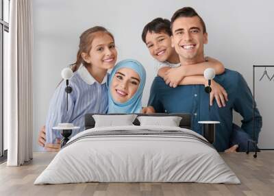 Portrait of happy Muslim family on light background Wall mural