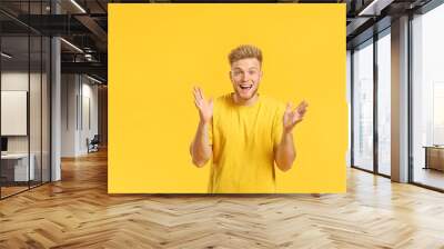 Portrait of happy young man on color background Wall mural