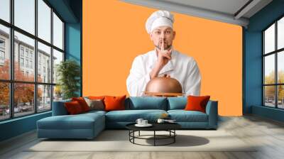 Portrait of male chef showing silence gesture on color background Wall mural