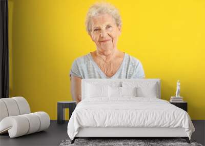 Portrait of senior woman on color background Wall mural