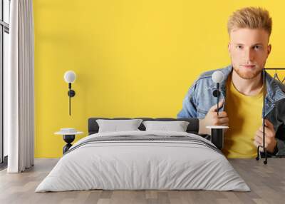 Portrait of stylish young man on yellow background with space for text Wall mural