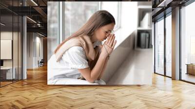 Praying young woman in office Wall mural