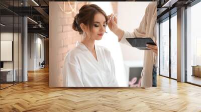 Professional makeup artist working with young bride at home Wall mural