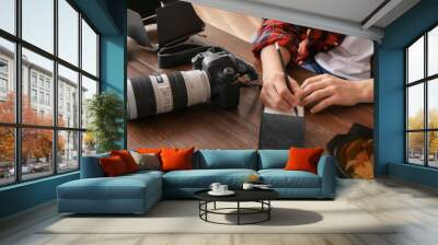 Professional photographer writing in notebook at table Wall mural