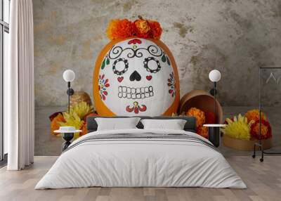 Pumpkin with painted skull and beautiful flowers on grunge background. El Dia de Muertos Wall mural