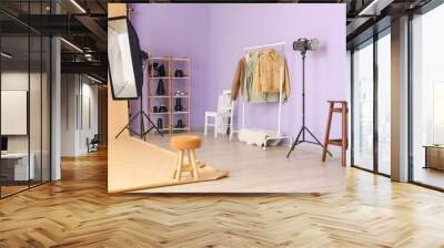 Rack with clothes, shelving unit and lighting equipment in modern photo studio Wall mural