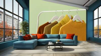 Rack with clothes on color background Wall mural