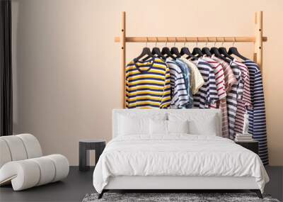 Rack with hanging clothes on color background Wall mural