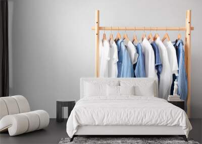 Rack with hanging clothes on light background Wall mural