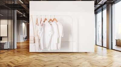 Rack with stylish clothes near light wall Wall mural