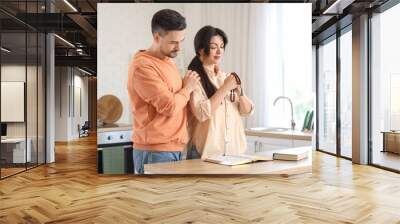 Religious couple praying with beads in kitchen Wall mural