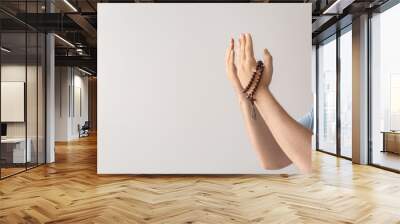 Religious man praying on light background Wall mural