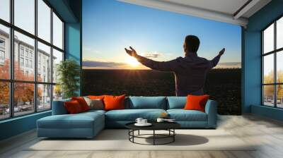 Religious man praying outdoors at sunset Wall mural