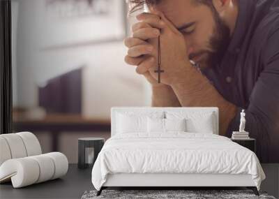 Religious young man praying to God at home Wall mural