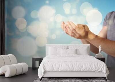 Religious young man praying to God on color background Wall mural