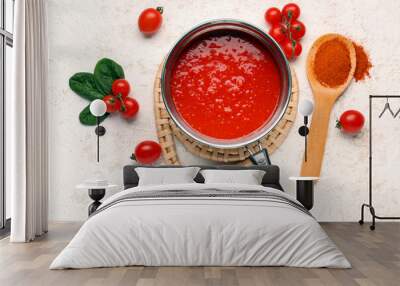 Saucepan with tasty tomato sauce and fresh vegetables on light background Wall mural