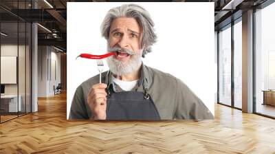 Senior man eating chili pepper on white background Wall mural