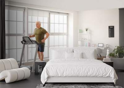 Senior man training on treadmill at home Wall mural