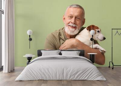 Senior man with cute dog on green background Wall mural