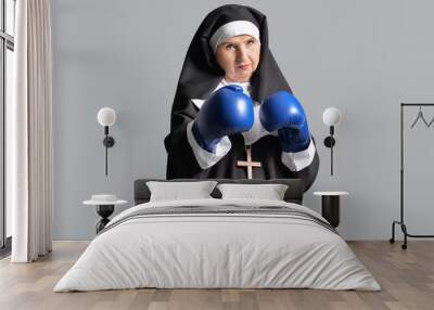 Senior nun in boxing gloves on grey background Wall mural