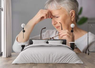 Senior woman suffering from headache at home Wall mural