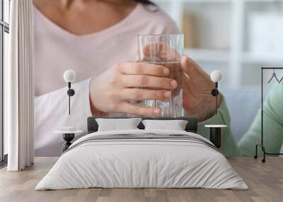 Senior woman taking glass of water from her daughter at home, closeup Wall mural