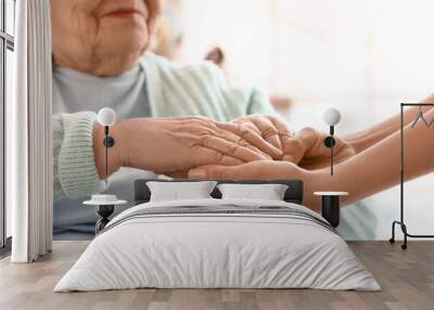 Senior woman with her granddaughter holding hands at home, closeup Wall mural