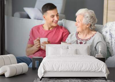 Senior woman with her grandson resting at home Wall mural