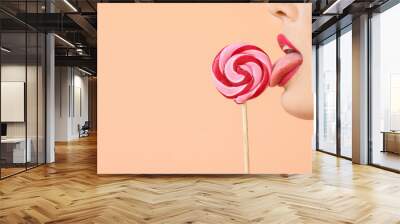 Sexy young woman with lollipop on beige background with space for text, closeup Wall mural