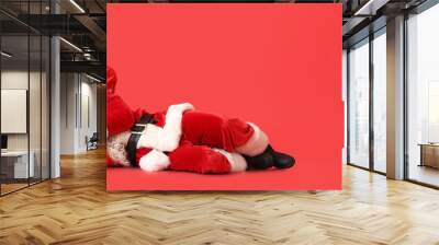 Sleeping Santa Claus with presents on red background with space for text Wall mural