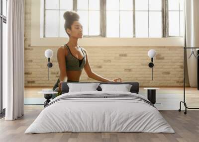 Sporty African-American woman practicing yoga indoors Wall mural